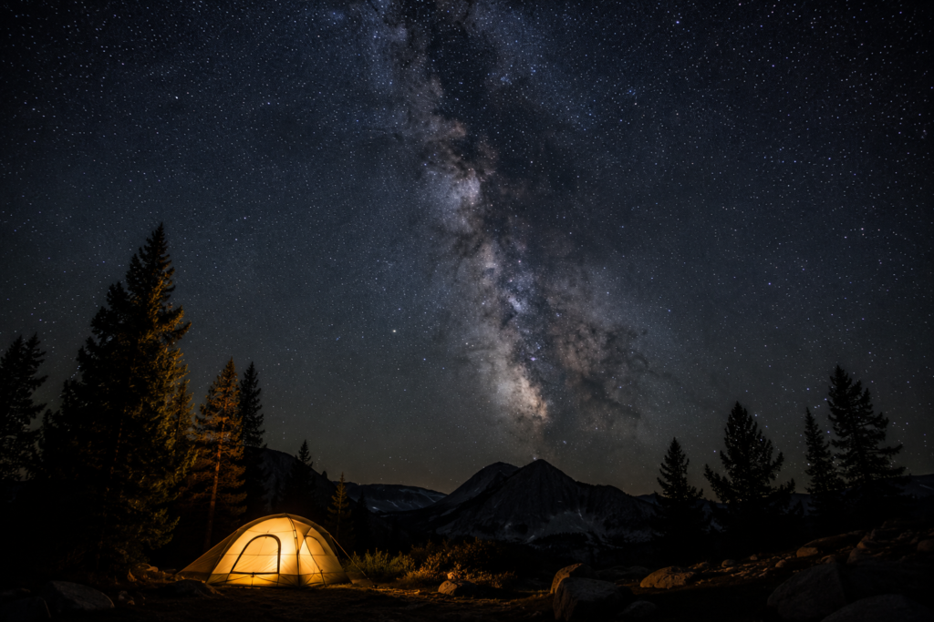 outdoor camping activities stargazing at night tent in foreground milky way and stars visible dark sky campsite
