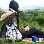 A solo female camper enjoying scenic beauty near her campsite