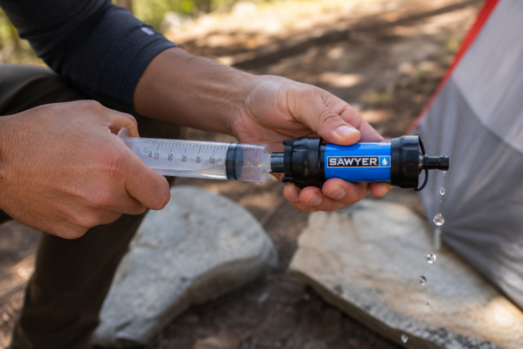 purifying water in the wilderness maintaining water filter backflushing Sawyer Squeeze syringe outdoor campsite