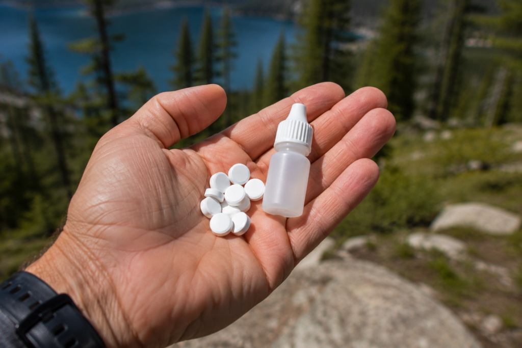 purifying water in the wilderness chlorine dioxide Aquamira drops and water purification tablets in palm outdoor